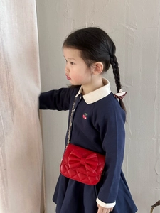 Sac bandoulière rouge matelassé pour fille avec nœud et chaîne dorée sur un mannequin