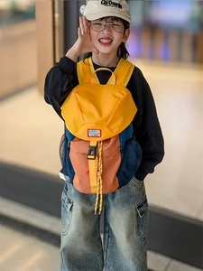 Detailed view of kids' colorblock backpack with yellow buckle and drawstring closure