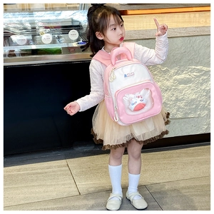 Close-up of pink children backpack featuring a transparent window with a plush cat toy