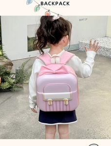 Pink and purple child hardshell backpack with a large 3D bow design on the back