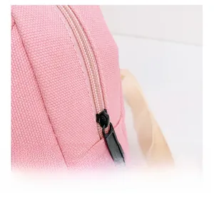 Detailed macro view of smooth pink canvas fabric and high-quality zipper on kids backpack