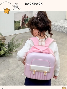 Detail view of pink and purple preschool backpack with a decorative 3D bow and striped pattern