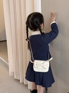 Détail du mini sac blanc matelassé pour fille avec nœud et chaîne dorée sur mannequin