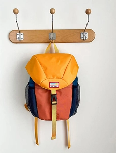 Detail of color-block kids backpack with yellow flap and mesh side storage pocket