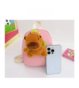 Pink mini canvas backpack and Capybara plush keychain compared to an iPhone for size
