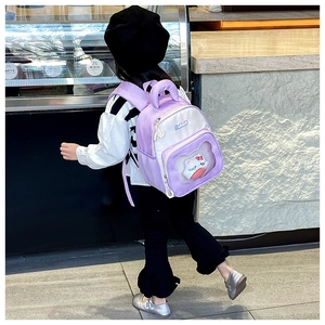 Kid wearing purple and white backpack with plush kitty doll in street setting
