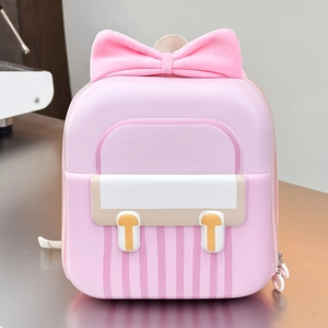 Detail of pink hardshell kid's backpack featuring large bow and waterproof EVA texture