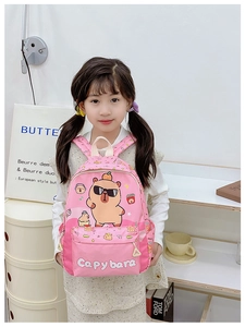 Zaino rosa per bambini con simpatica stampa Capybara indossato da un bambino a casa