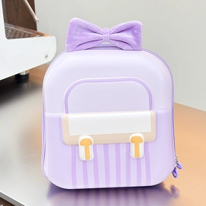 Detail of lavender school bag featuring a plush velvet bow and striped hardshell design