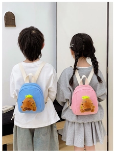 Detail showing blue and pink children's backpacks with plush capybara animal designs