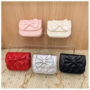 Détail de cinq couleurs de mini sacs matelassés avec de grands nœuds décoratifs