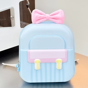 Detail of light blue hardshell backpack featuring a pink bow and yellow decorative buttons