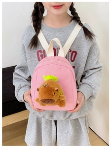 Detailed shot of kids pink canvas backpack featuring a cute 3D plush capybara toy
