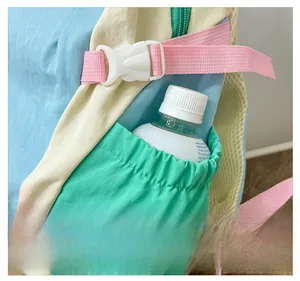 Detail view of the side elastic pocket holding a water bottle on a multi-color kids backpack