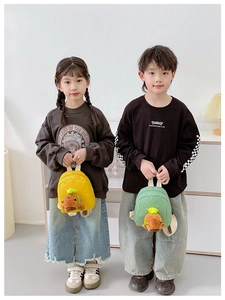 Close-up of yellow and green mini backpacks with plush capybara charms for kids