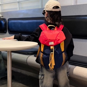Kids color-block backpack in red, blue, and yellow with buckle detail on model