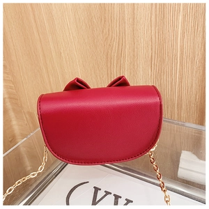 Detail of red PU leather girls purse featuring bow decoration and gold chain strap