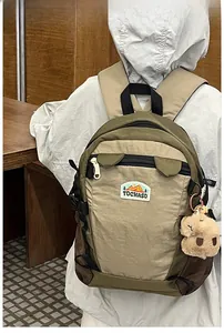 Rear view of child wearing Earth-tone outdoor backpack with plush charm and brand patch
