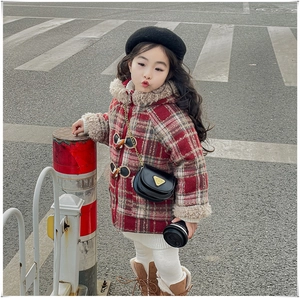 Détail d'un manteau enfant à carreaux rouge et blanc avec boutons duffle-coat et bordure