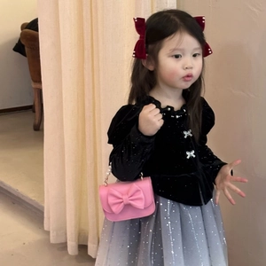 Detail of girl's black velvet top with pearl bow and pink crossbody chain bag