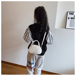 Détail d'un mini sac à main blanc pour enfant avec matelassage en cœur et bandoulière réglable