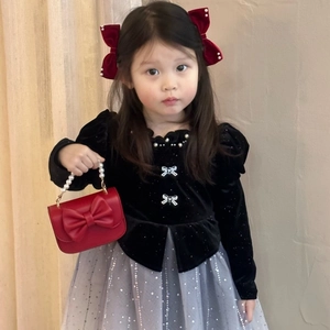 Detail showing girls velvet top with pearl bow and matching red handbag accessory