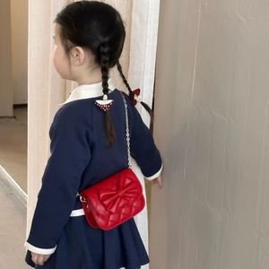 Sac bandoulière matelassé rouge pour fille avec grand nœud et chaîne dorée sur modèle