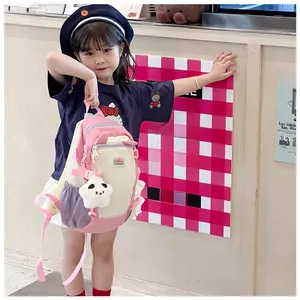 Front view of a cute cartoon children's backpack featuring plush star charm and multi-color