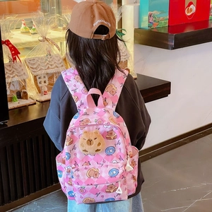 Sac à dos rose à carreaux Capybara pour enfant avec peluche, porté par un jeune modèle