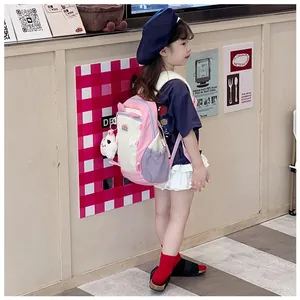 Kids backpack with side mesh pocket and cute plush charm shown on a child model
