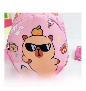 Close-up of pink kids crossbody bag featuring cartoon capybara print and metal zipper