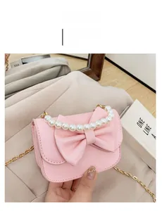 Pink girl's crossbody bag with elegant bow, pearl handle and golden chain strap