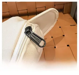 Nahaufnahme eines glatten schwarzen Markenreißverschlusses an einer cremefarbenen Tasche