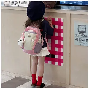Detail of pink and purple kids backpack featuring side pockets and a cute plush charm