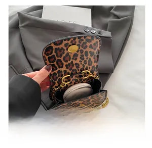 Vue de la capacité du mini sac léopard avec chaîne montrant le rangement cosmétique