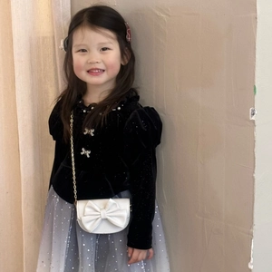 Detail of girls princess outfit with velvet top, sequin mesh skirt and bow chain bag