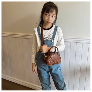 Mini sac à bandoulière pour fille avec motif cœurs surpiqués porté par un enfant mannequin