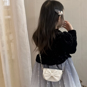 Detailed view of kids white bow crossbody bag with gold chain and matching hair clip