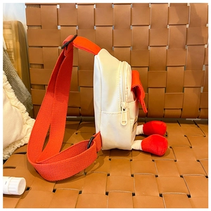 Vue détaillée du sac de poitrine maison avec pieds en peluche rouges sur un siège