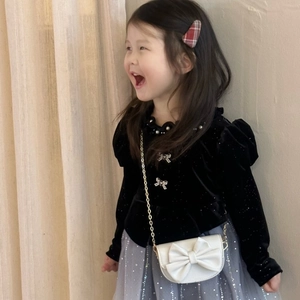 Close-up of white leather bow crossbody bag with gold chain for little girl outfit
