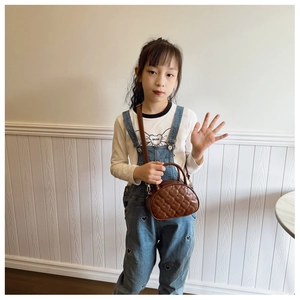 Détail du sac à main marron pour enfants avec motifs cœurs surpiqués et poignée robuste