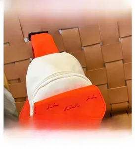 Détail du sac maison avec texture sergé orange et broderies de vagues rouges élégantes