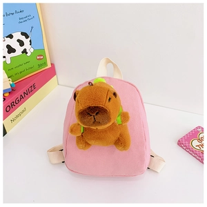 Detailed close-up of pink canvas toddler backpack with a plush Capybara doll on front