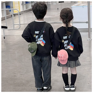 Detail der Kinderkapuzenpullover mit Buchstabendruck und süßen Mini-Umhängetaschen