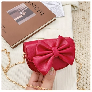 Detail of red bow mini crossbody bag for girls with gold chain strap and litchi texture