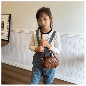 Détail de la texture matelassée en cœur et poignée ronde du mini sac marron enfant