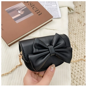 Handheld view of mini black bow crossbody bag with gold chain and lychee texture