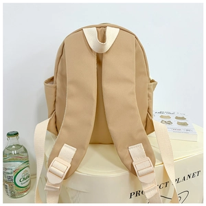 Detail of adjustable cream woven straps and side pocket on the khaki school backpack