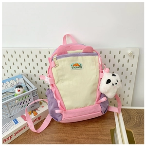 Close-up of colorful patchwork kids backpack with cute cat ears and panda plush charm