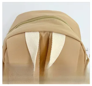 Detail view of reinforced cream handle and nylon texture on kids burger backpack